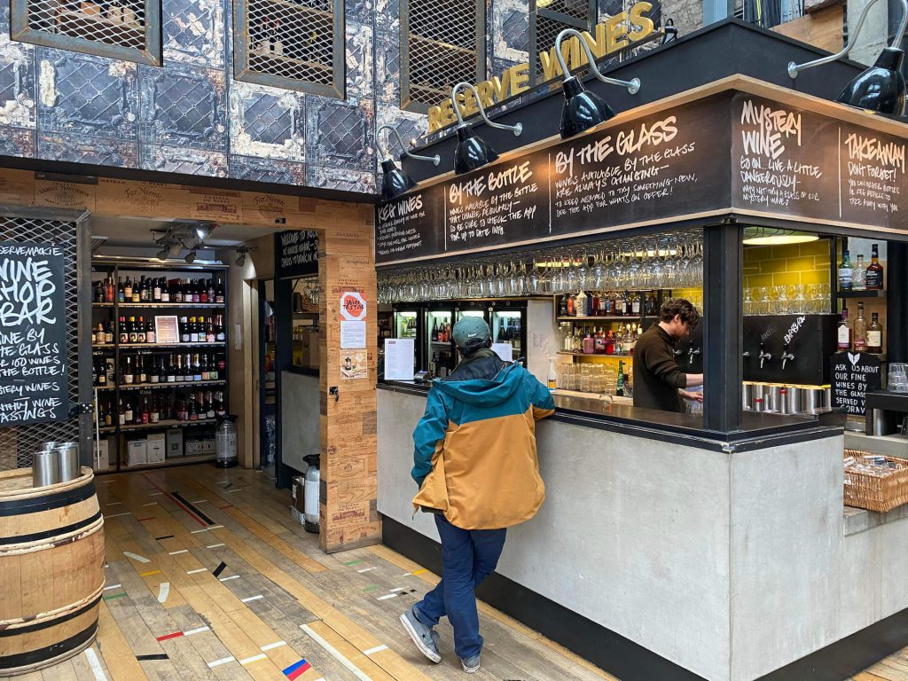 A customer leans on the bar waiting at Mackie Mayor food hall in Manchester | Manchester Bites Food Tours