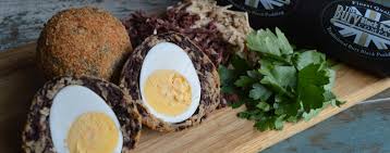 A Manchester Egg cut in half to show the pickled egg inside a case of pork and black pudding.